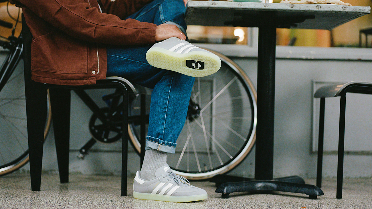 A man sitting with his legs crossed, showing the underside of his cycling shoe.