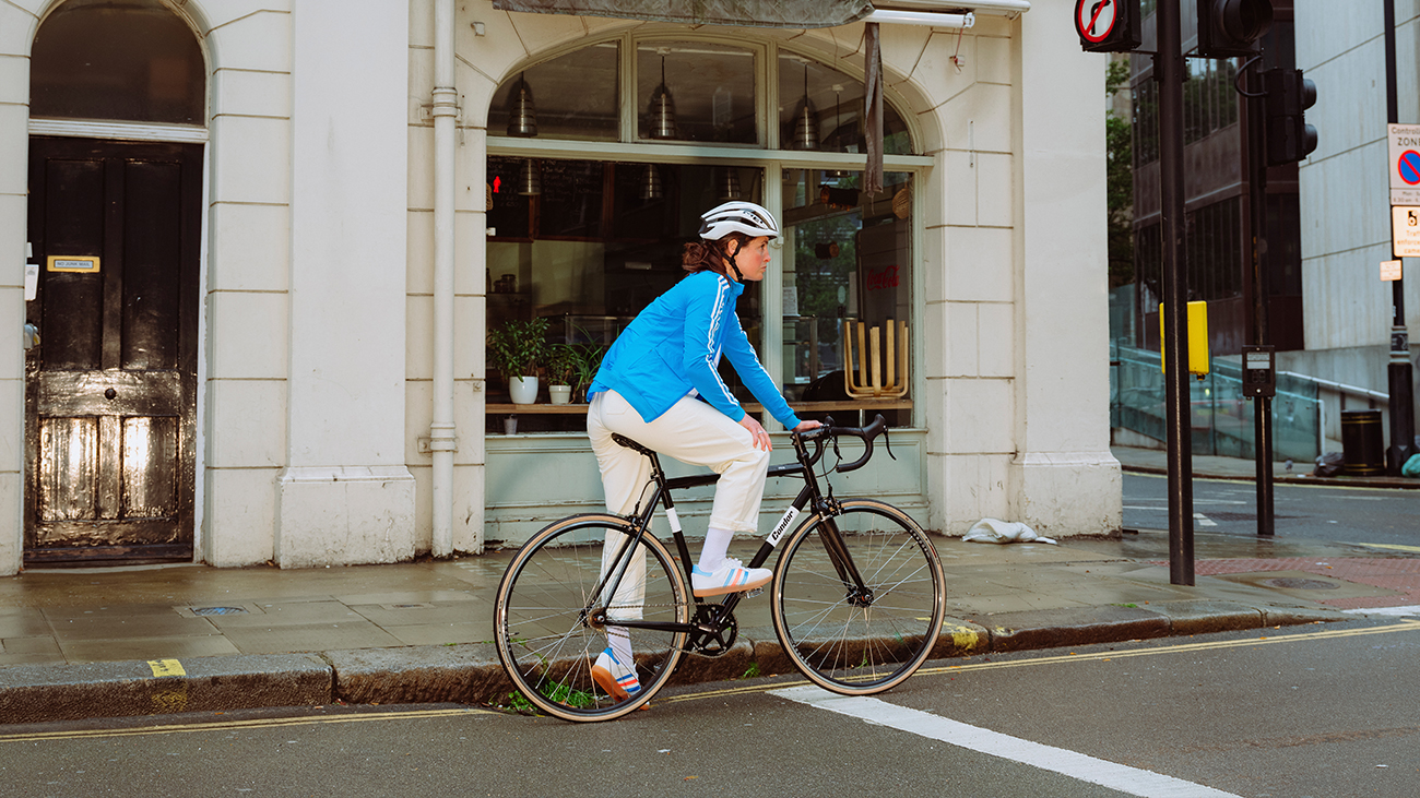 A women cyclist, clipped into her bike, waits at traffic lights