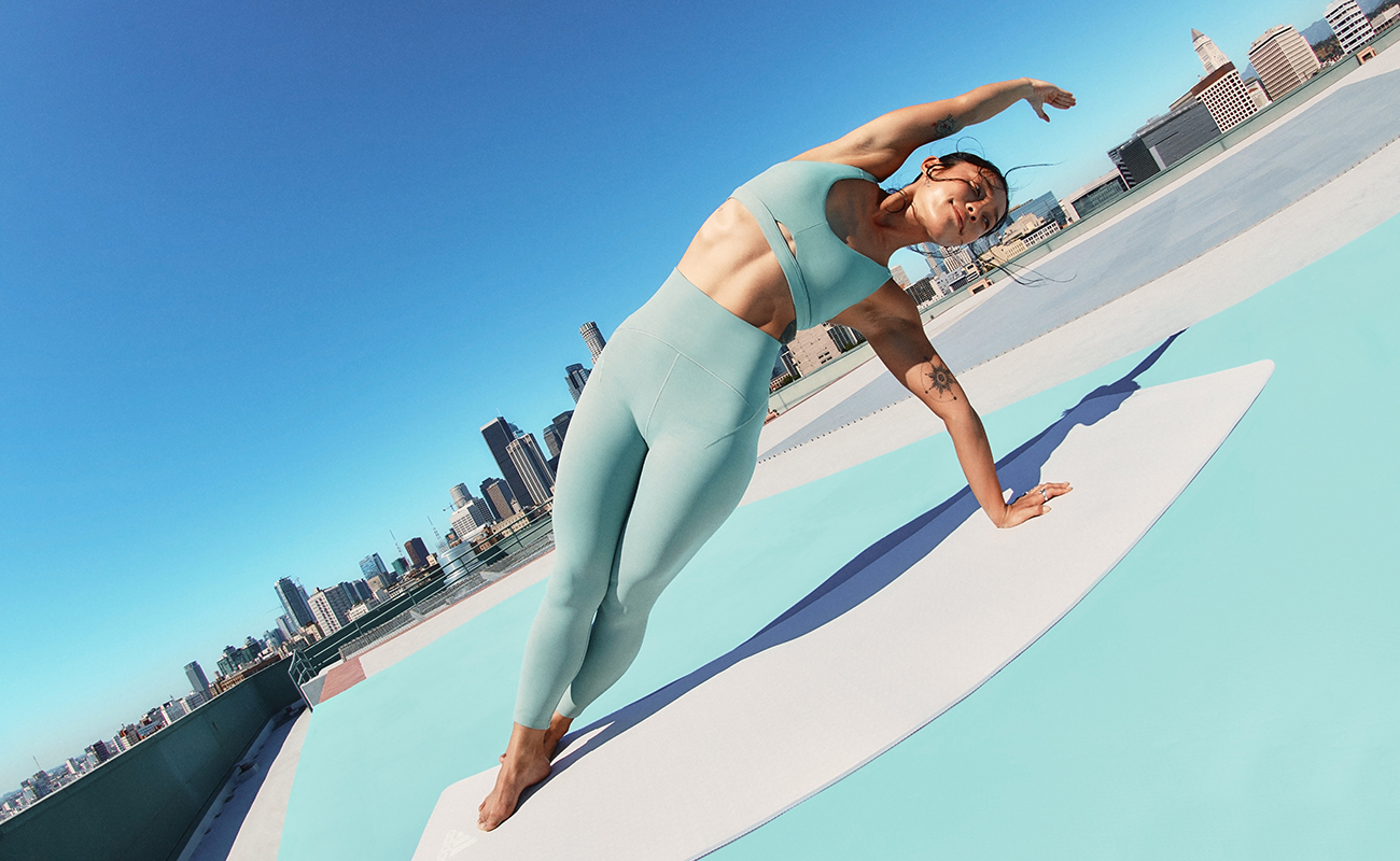 Modelka w biustonoszu sportowym i legginsach z kolekcji adidas