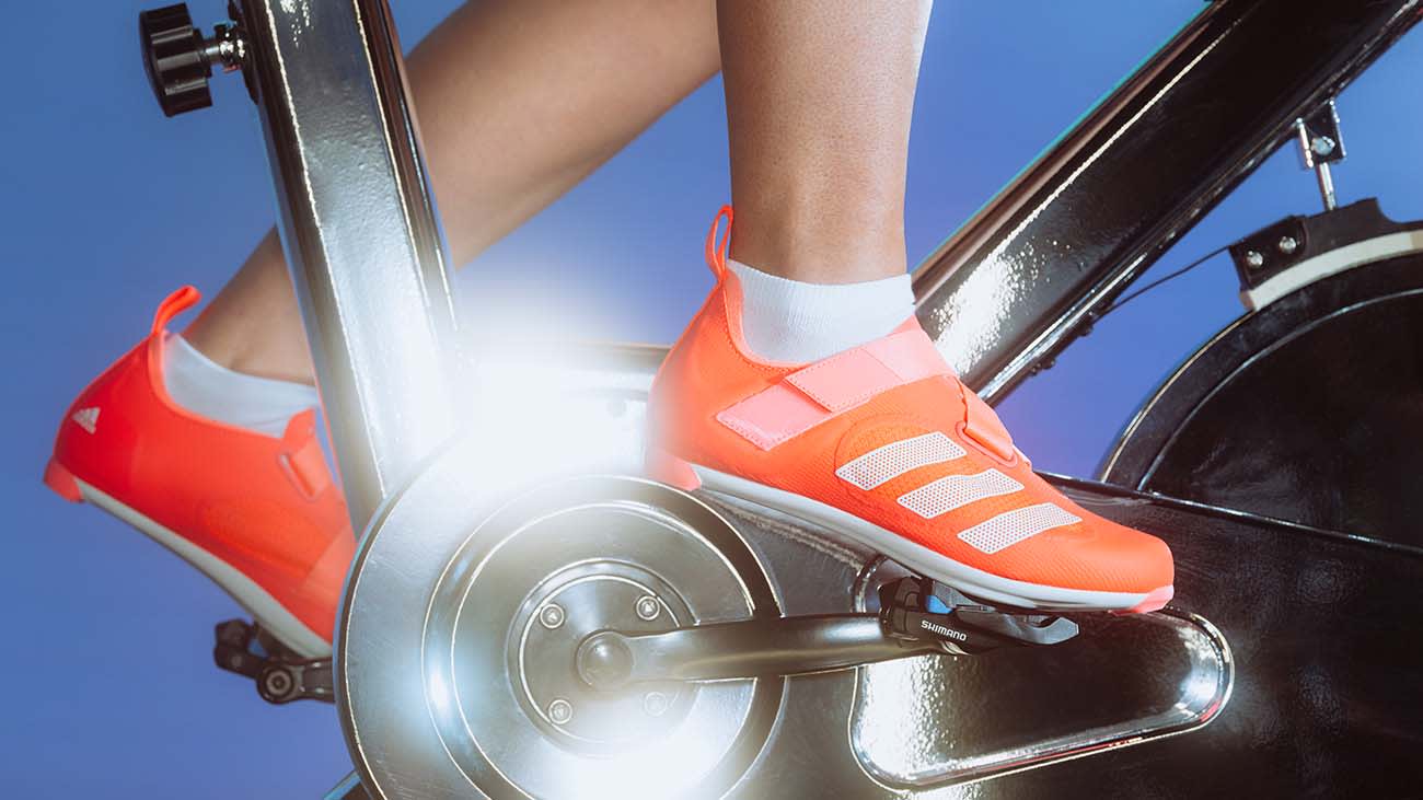 A close up image of a cycling shoe clipped into an exercise bike.