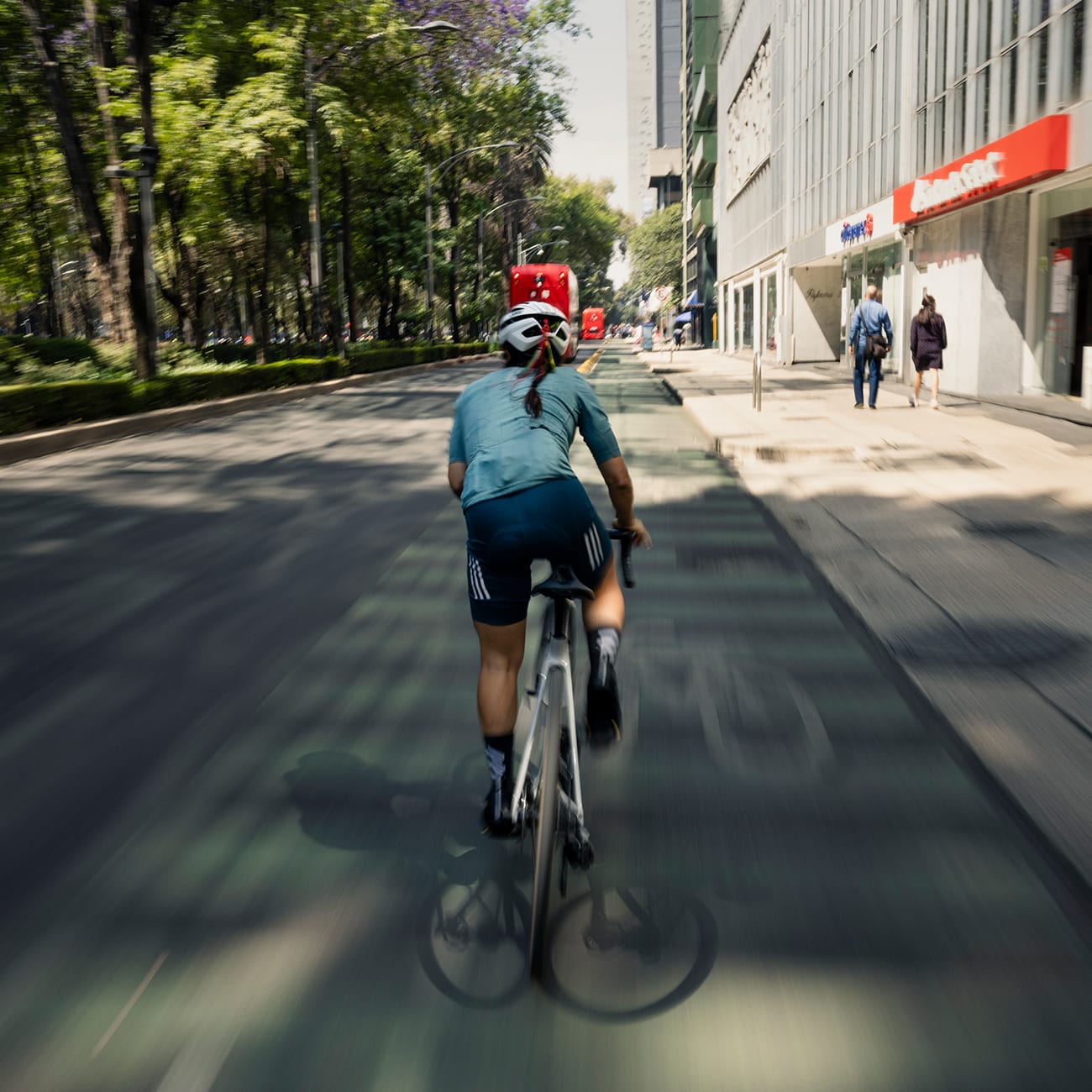 A woman cycles through the street of Mexico City at a fast pace