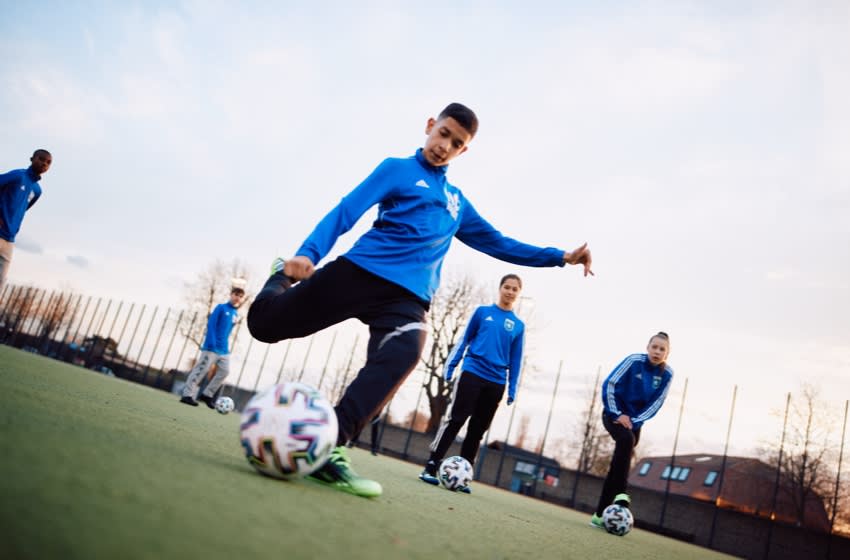 football-fw21-euro-202One-afc-blog-embed-image-1 FC Internationale Berlin gioca con il pallone all'interno del campo di allenamento outdoor.