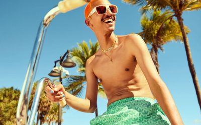 adidas-model-in-green-trefoil-allover-swim-shorts-yellow-sunglasses