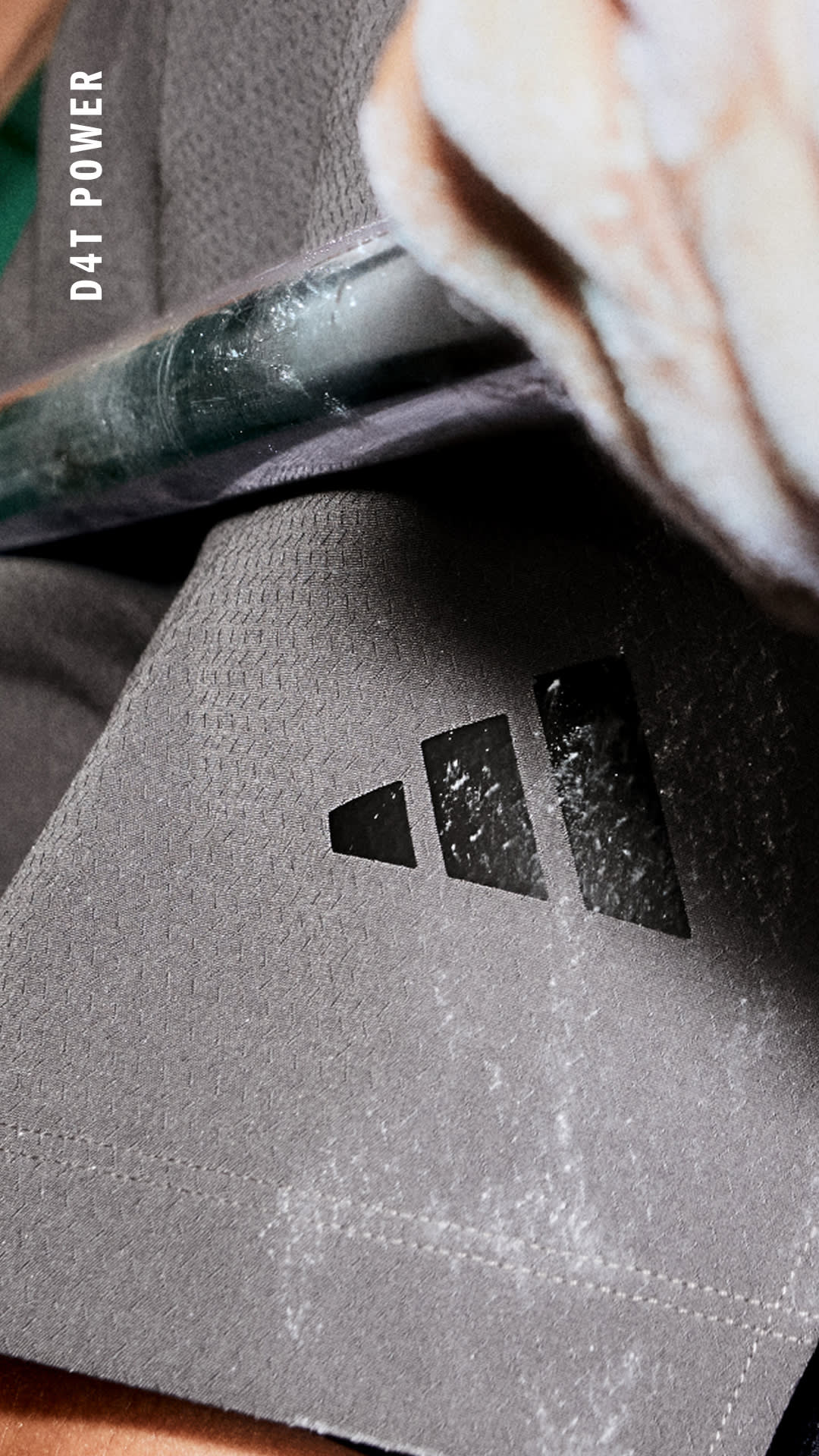 Das Bild zeigt eine Nahaufnahme einer grauen, strukturierten Oberfläche mit einem kleinen, dreieckigen Symbol oder Logo in der Mitte.