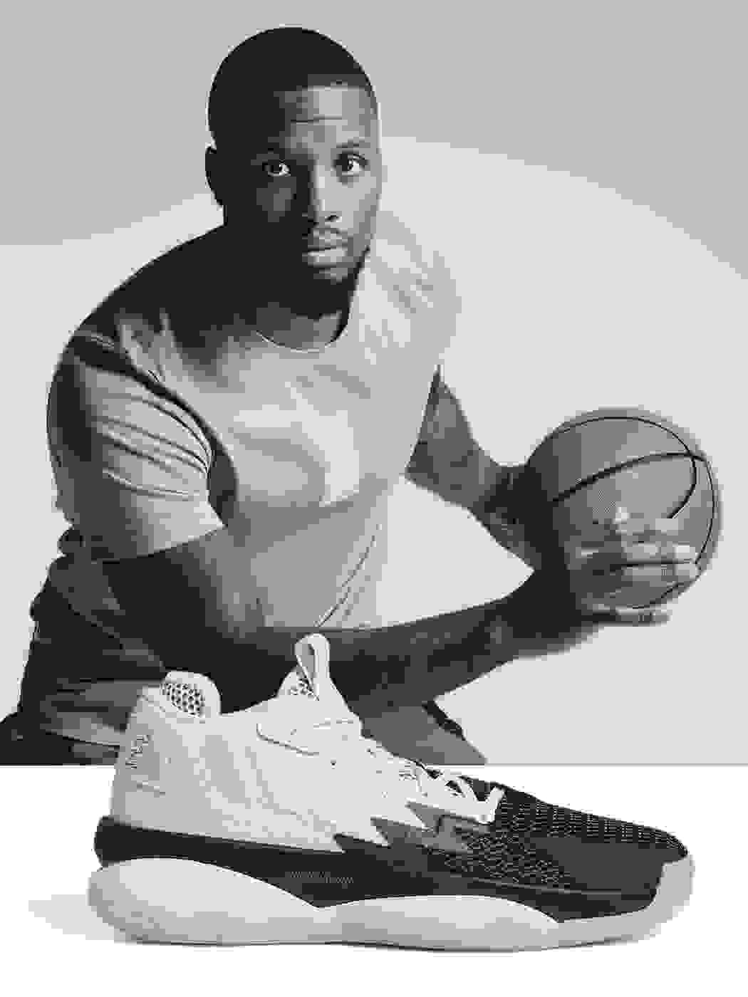 Professional basketball player Damian Lillard holding a basketball with a white and black shoe in the front.