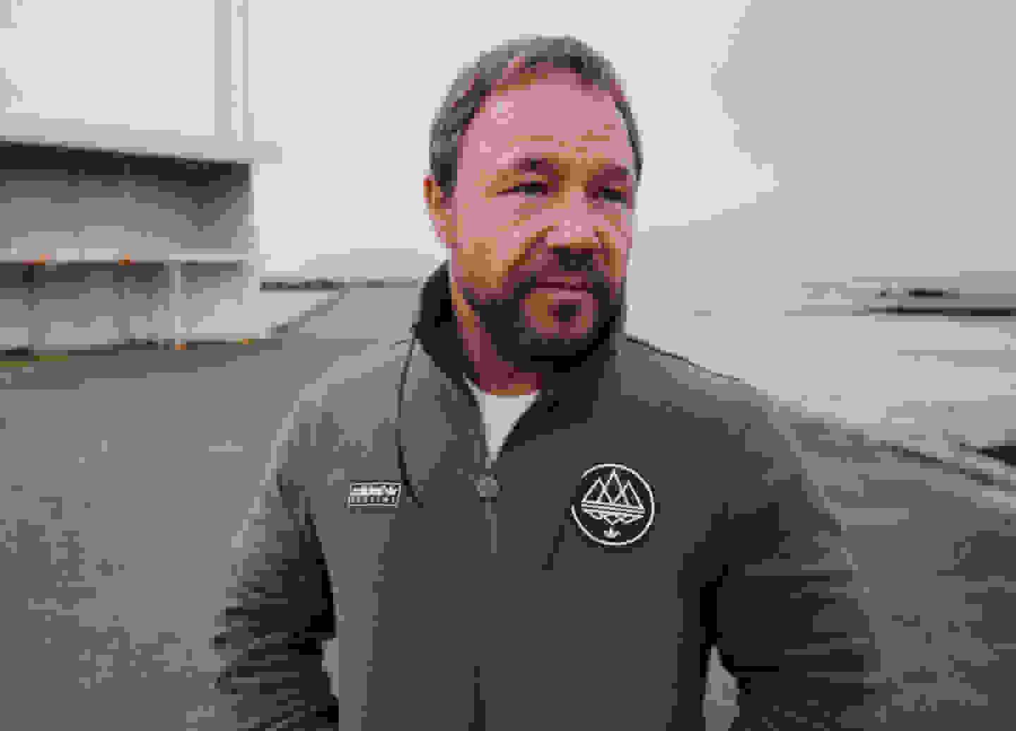 Stephen Graham stands in an industrial landscape and gazes into the distance while wearing the Pre-Spring 2023 adidas Spezial collection.