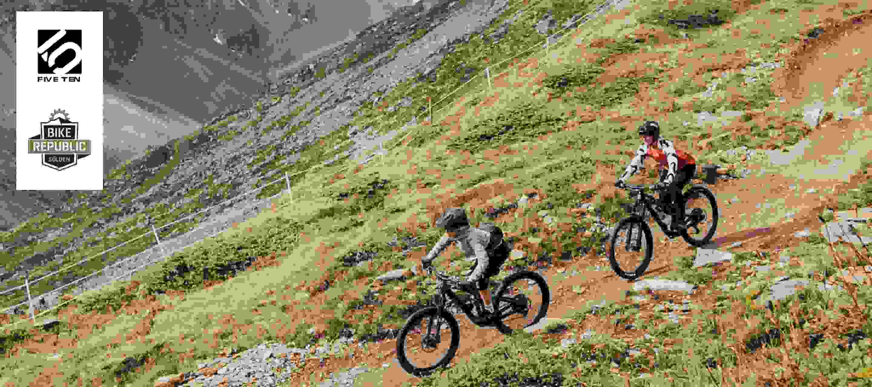Two mountain bikers riding down a hill