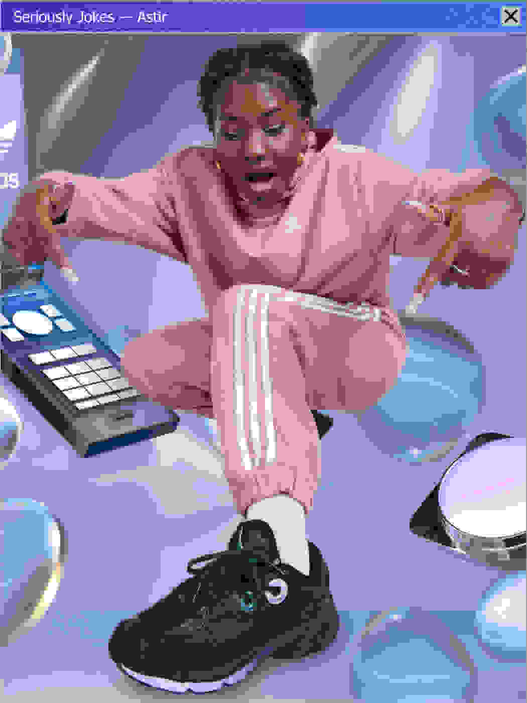 A crouching model is wearing the Astir sneaker in a Y2K nostalgic dynamic 3D animated world of oversized silver bubbles and a flip phone.