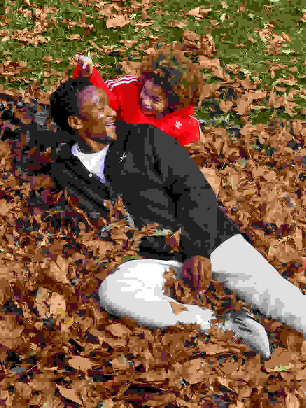 Father and son playing in Fall leaves.