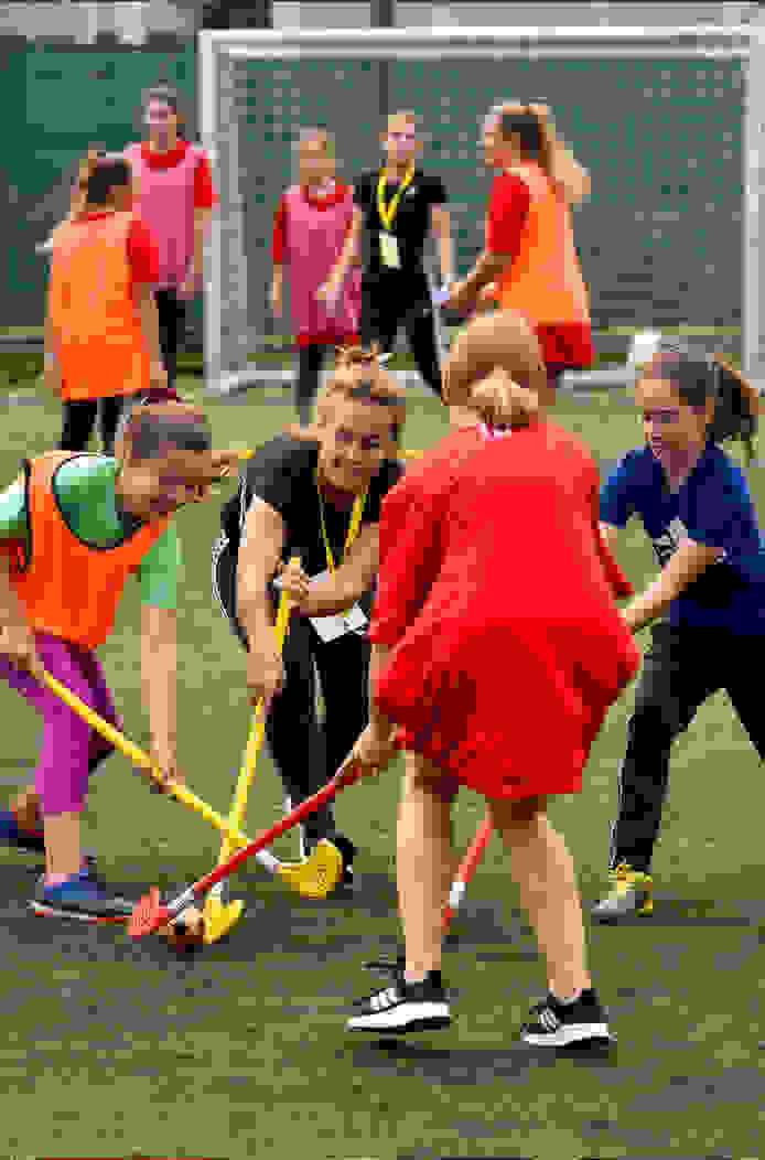 CCPA Champion playing hockey with young athletes