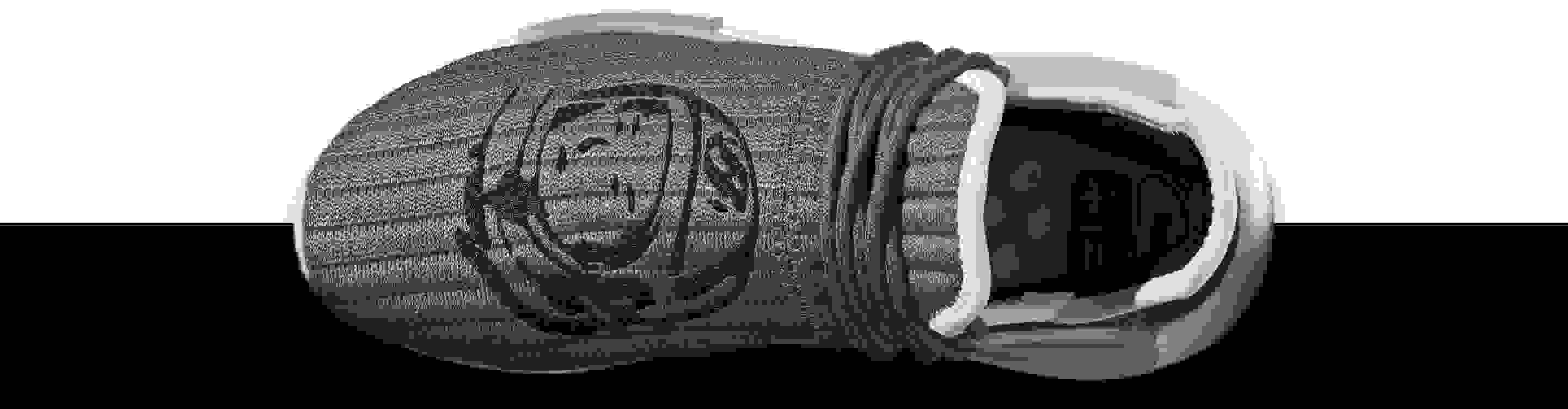 A close-up of the rib-knit upper with the BBC helmet logo and side view of the HU NMD BBC, hovering space above the moon's surface.