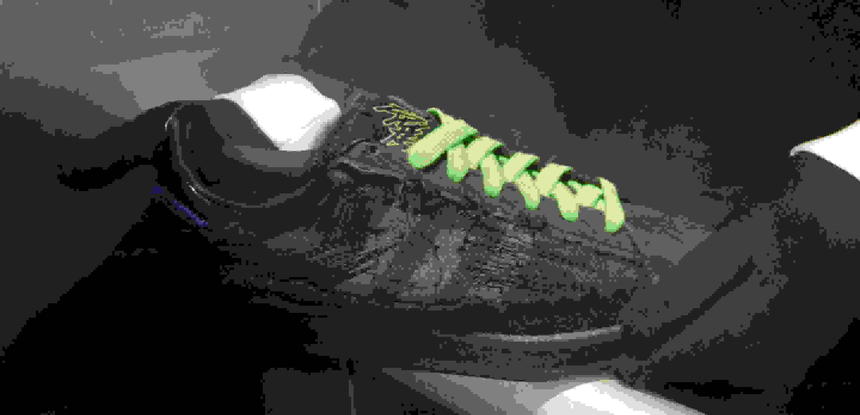A close-up of the black Campus80s with neon green laces and the graffiti Youth of Paris logo on the tongue.