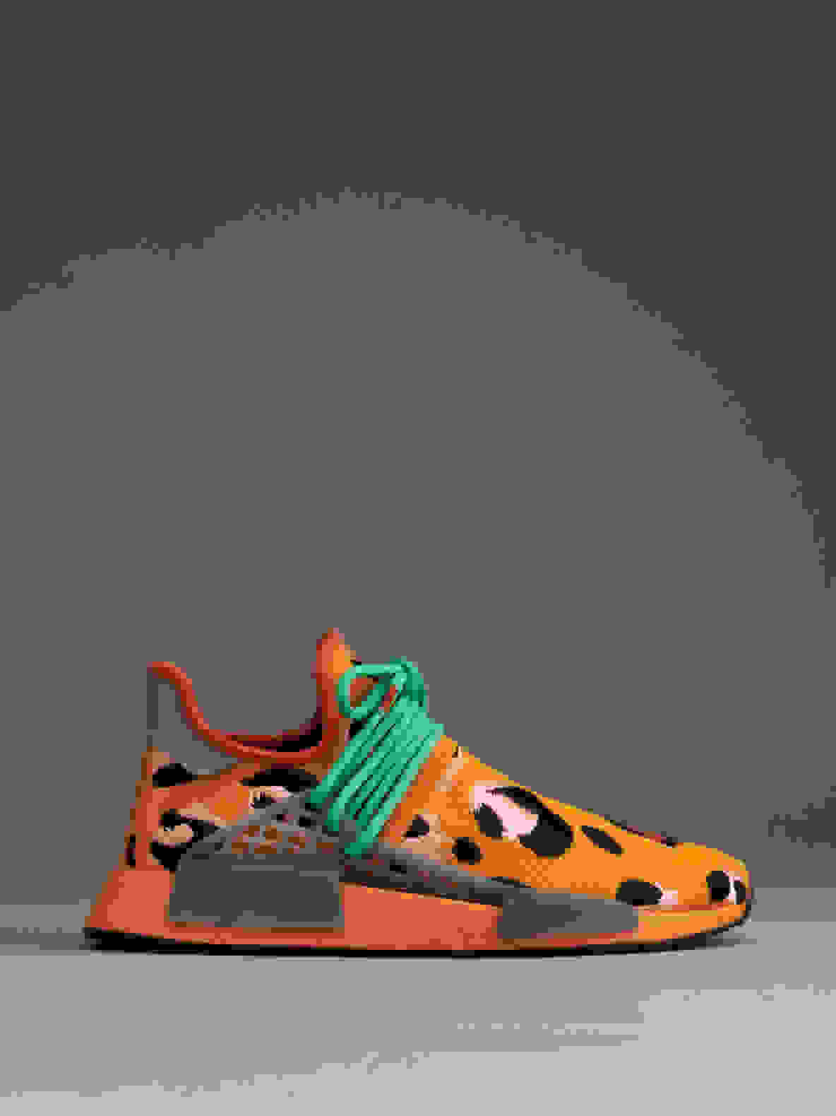 Side view of orange Hu NMD Animal Print shoes against gray background