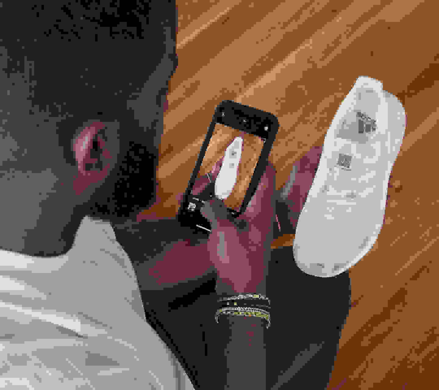 A man taking a picture of a white shoe