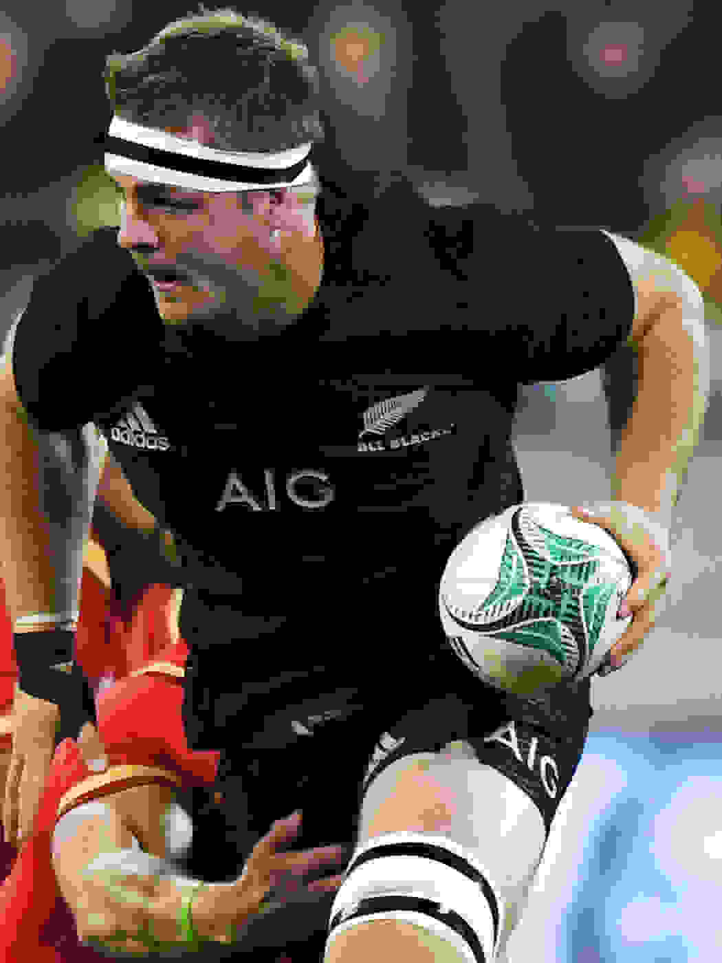 Sam Cane of All Blacks, driving forward with the ball in a match.
