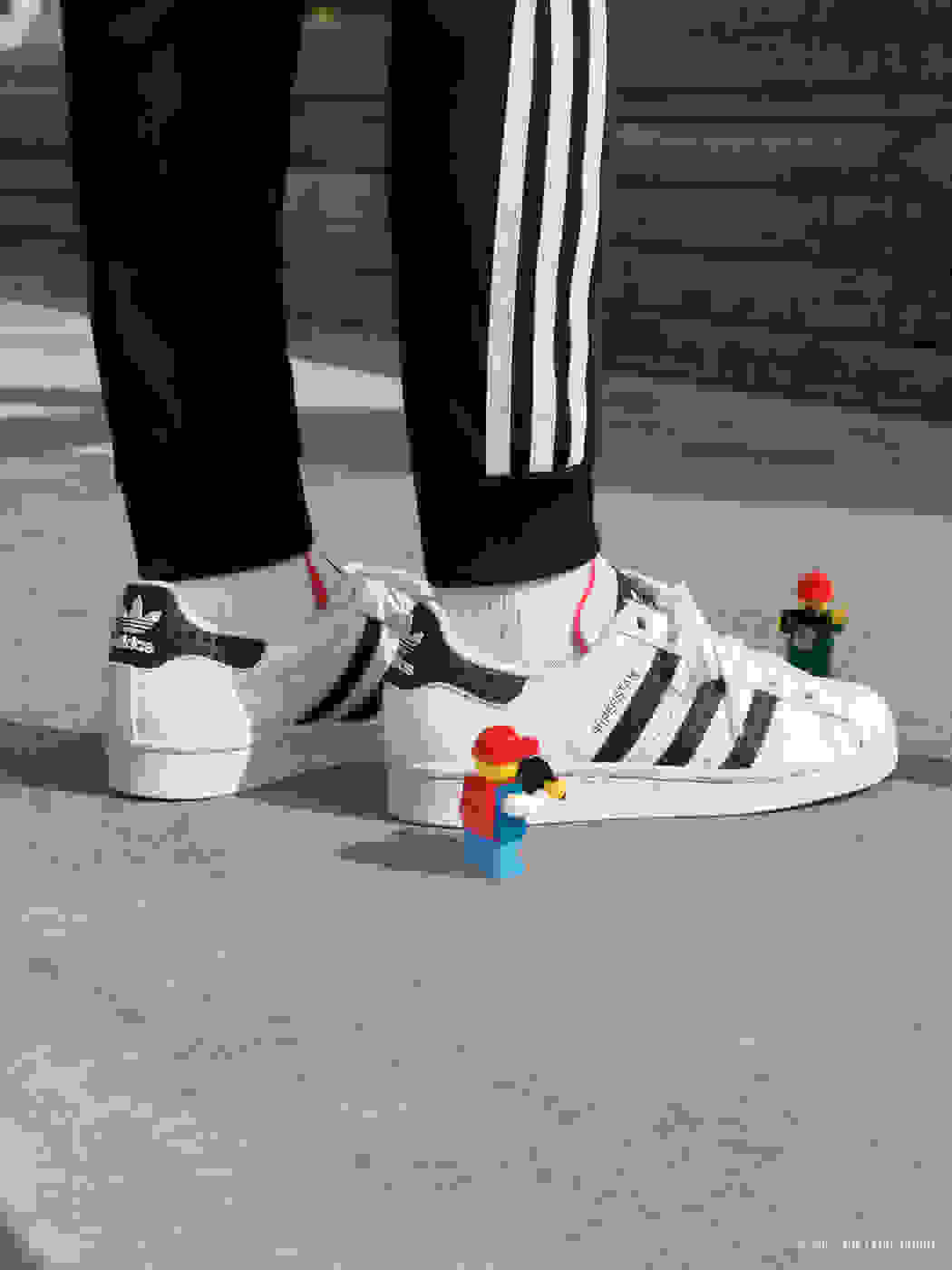 Child wearing adidas Originals LEGO Superstar&nbsp; with LEGO papparzzi minifigures