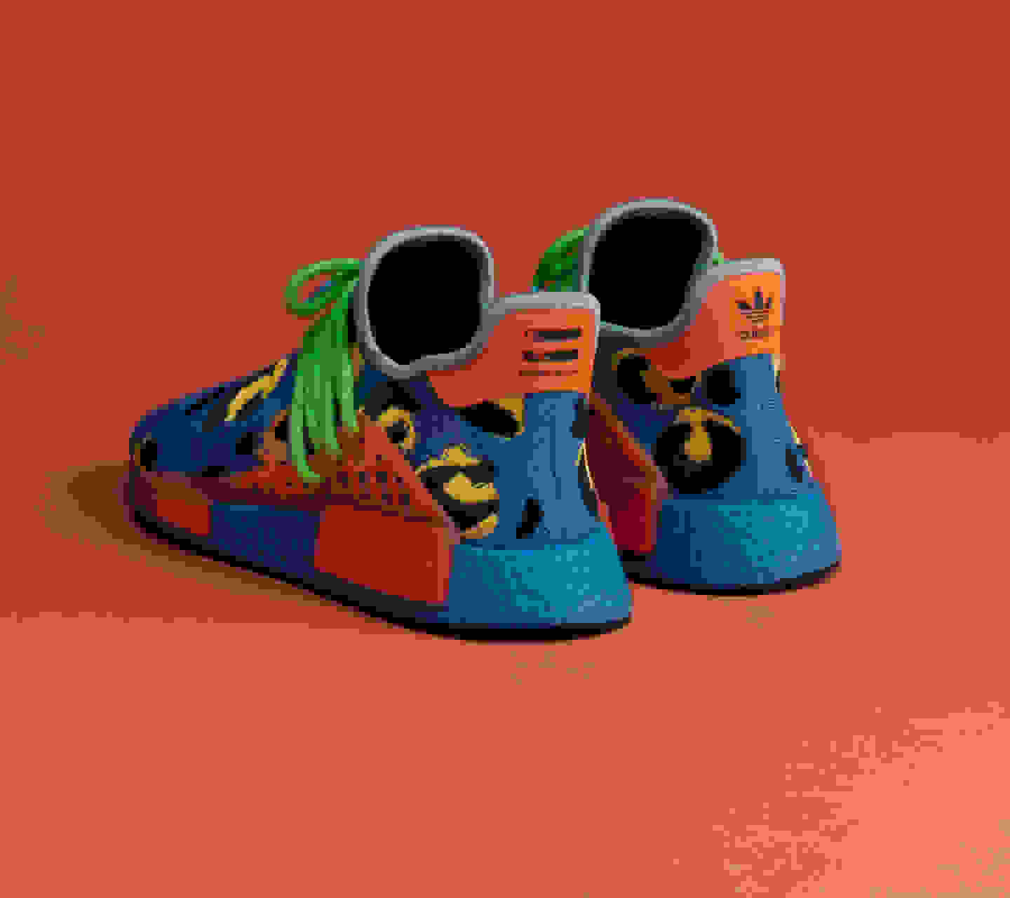 Rear view of pair of blue animal print shoes on orange background.