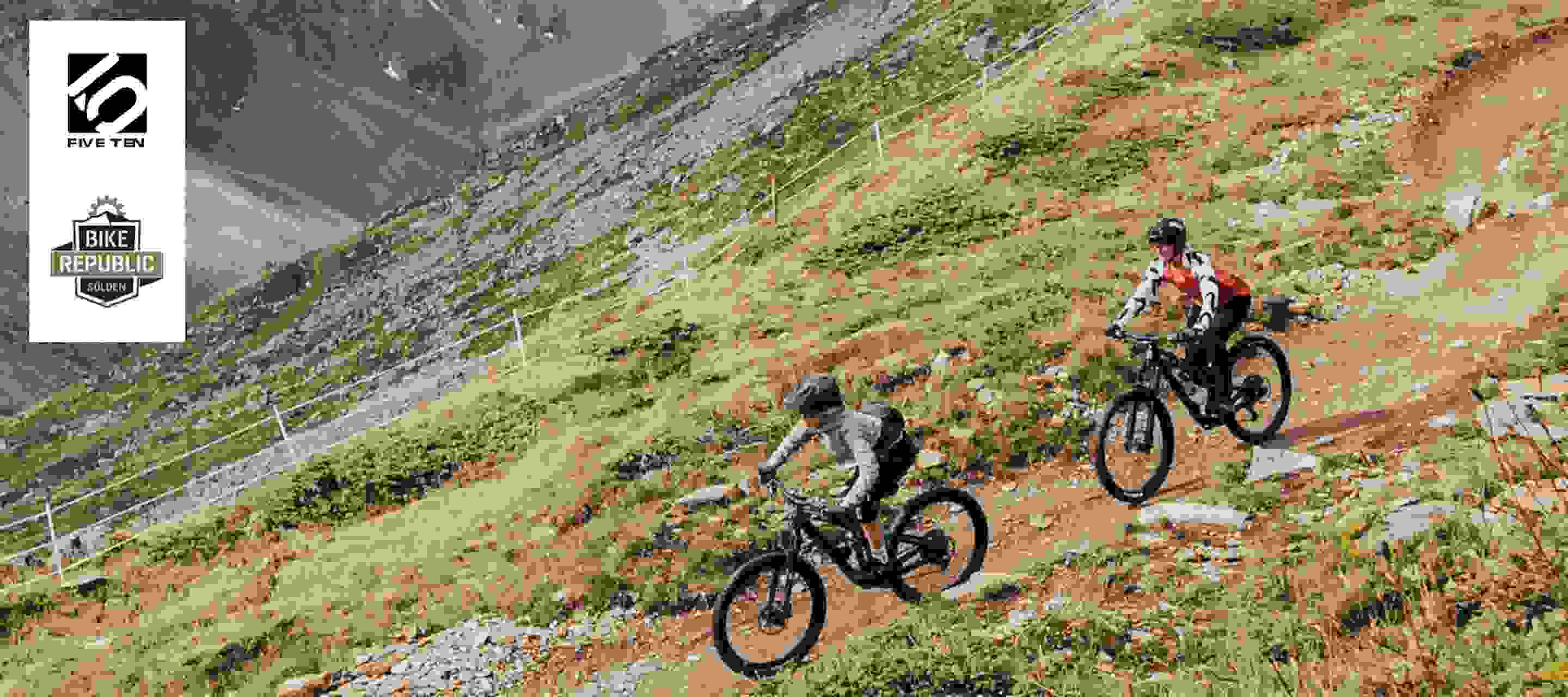 Two mountain bikers riding down a hill