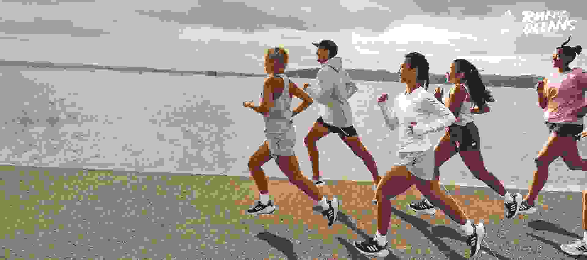 Group of men and women running by the ocean