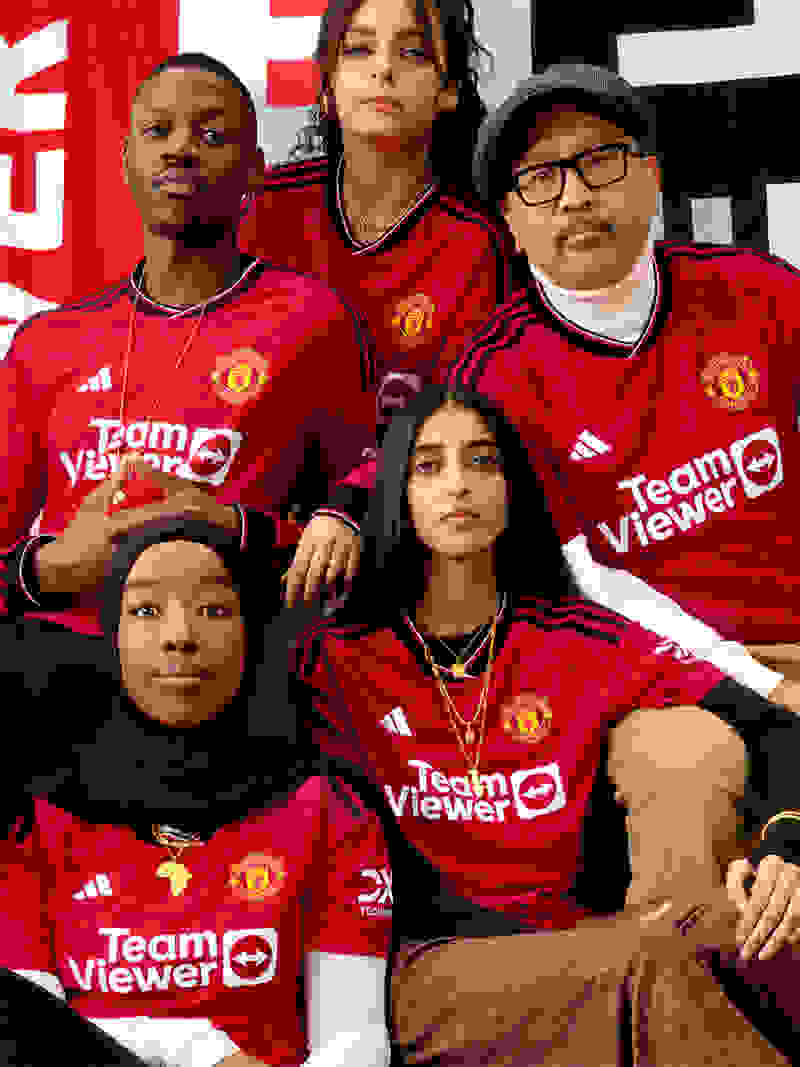 Visual of a dual gender group of Manchester United fans wearing the new Manchester United 23/24 Home kit