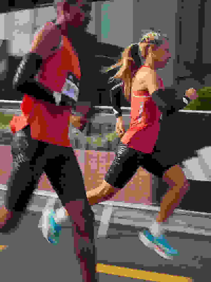 Close-up on male and female athletes running in Adizero apparel