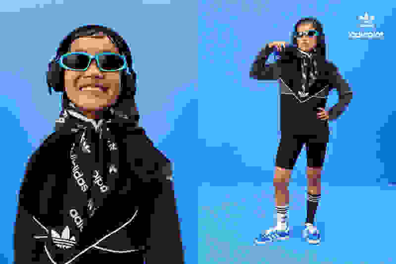 A young child poses in a full adicolor outfit with main character attitude.