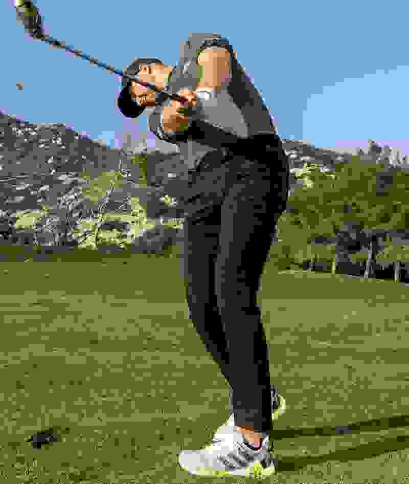 Daniel Berger swings a golf club in CODECHAOS golf shoes.