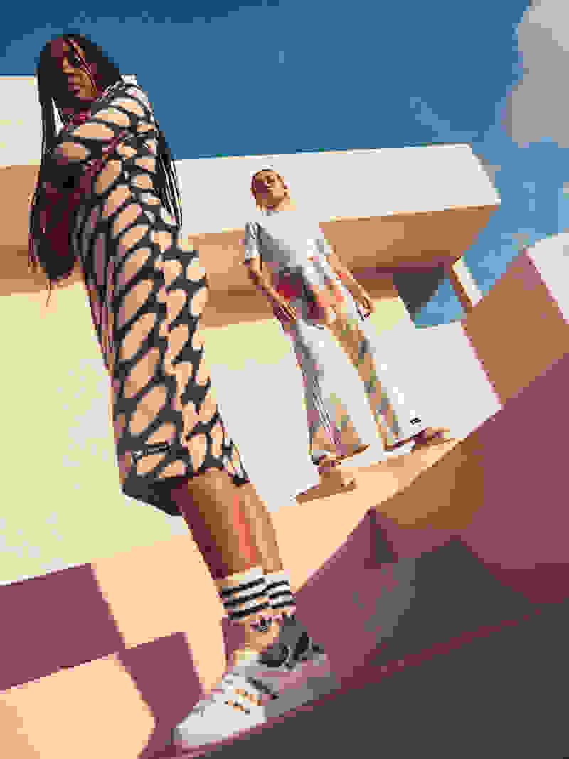 Two women standing on steps, wearing the adidas x marimekko collection.
