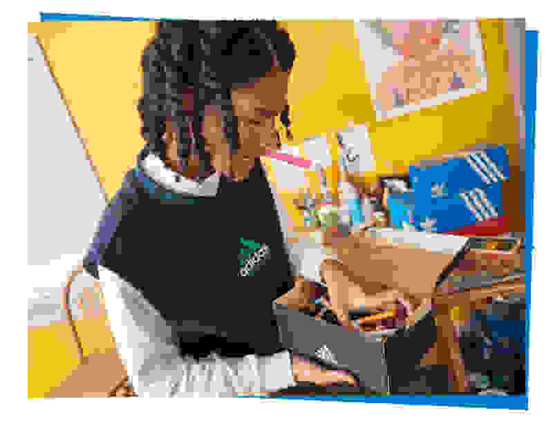 A close-up photo of a character who chooses the right markers in a box with a large number of colorful markers