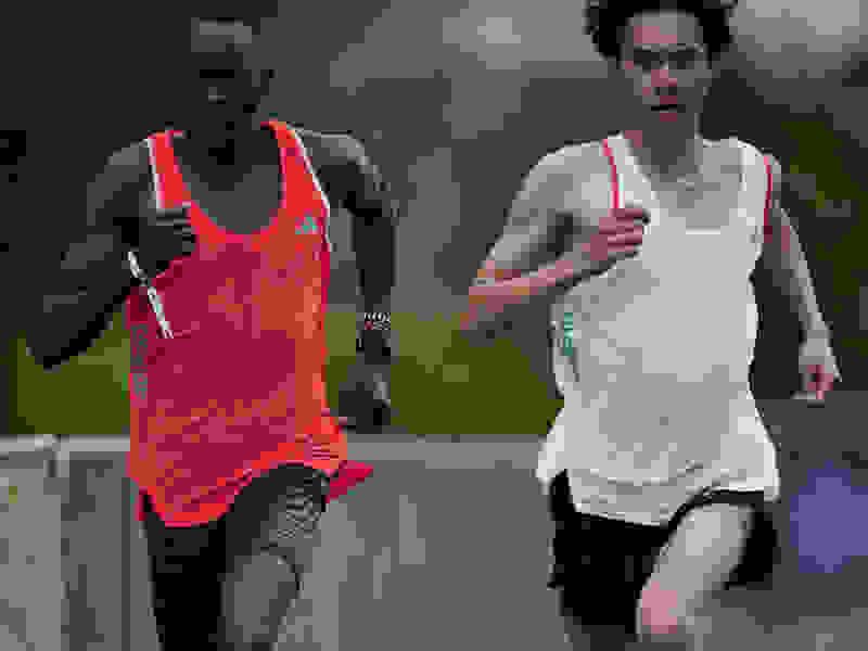 Two athletes run together in training.
