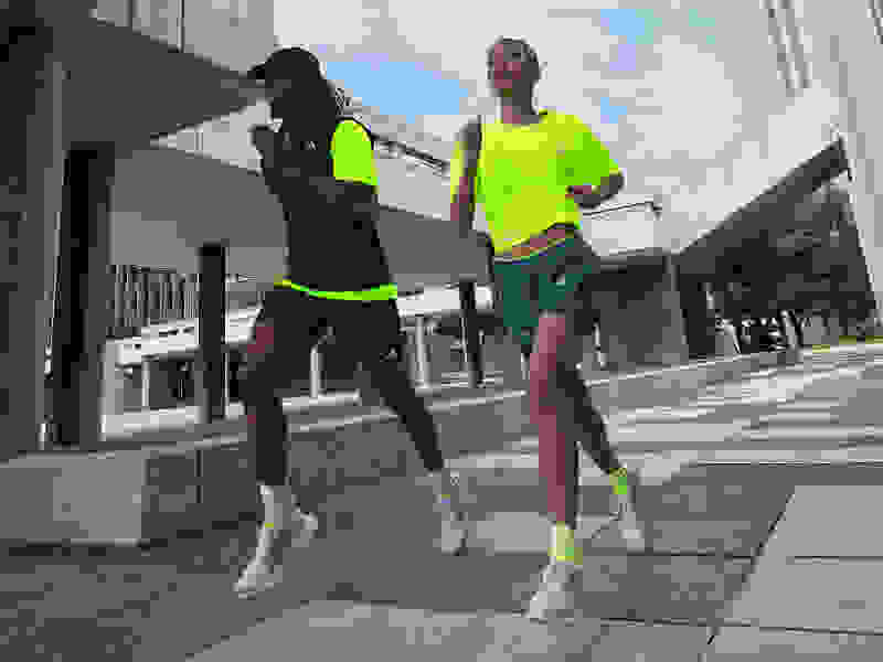 Male and female athlete run in the city wearing 4DWFD shoes and apparel.
