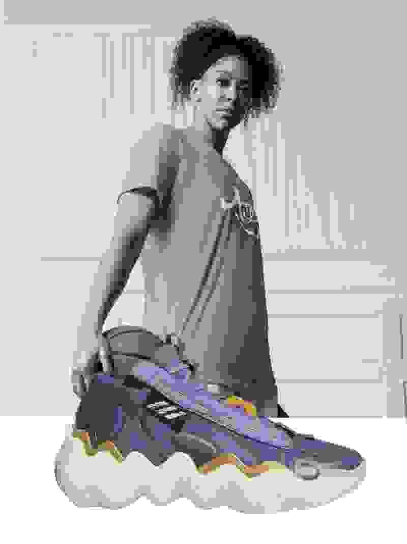 Professional basketball player Candace Parker wearing a long T-shirt with a purple and white shoe in the front.