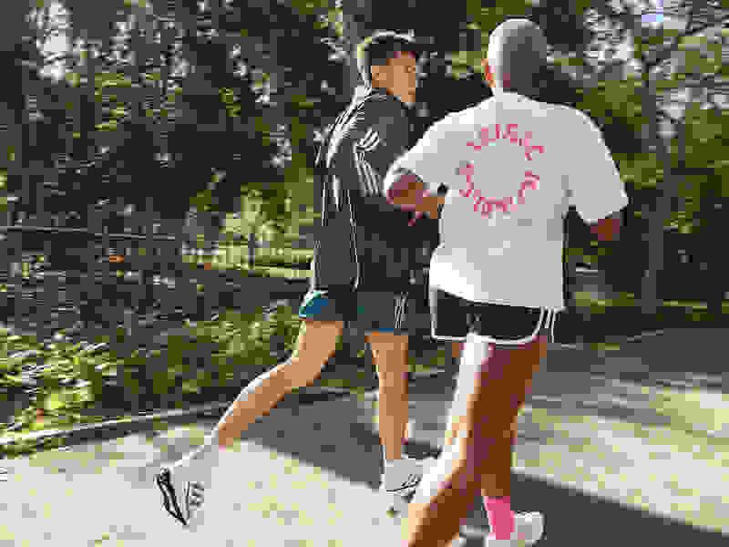 Runners stretch for daily run in park, wearing Supernova running shoes.