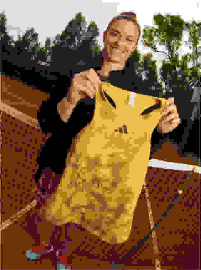 Visual of Maria Sakkari holding her signed tank top