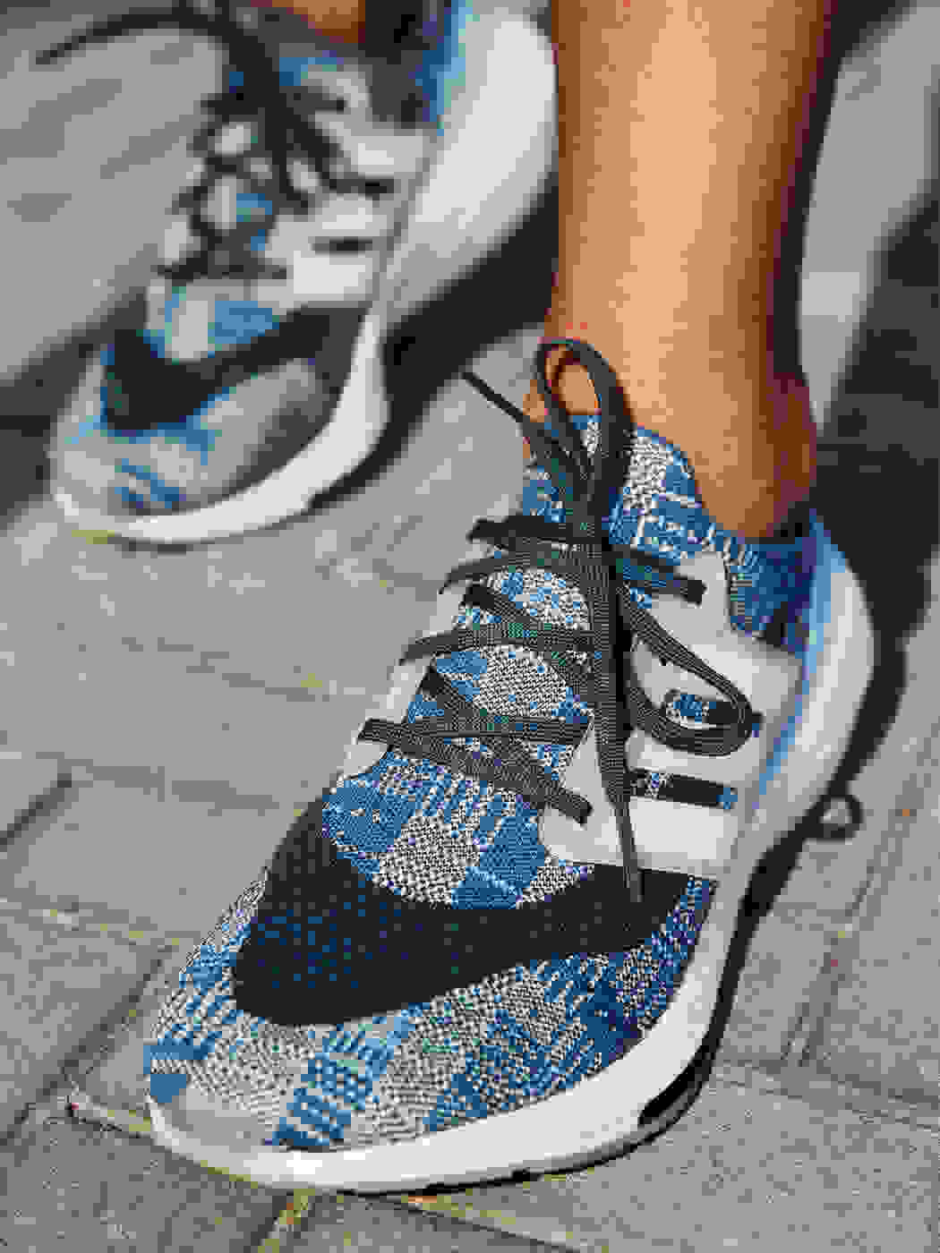 A person is wearing Primeblue Ultraboost 21 running shoes
