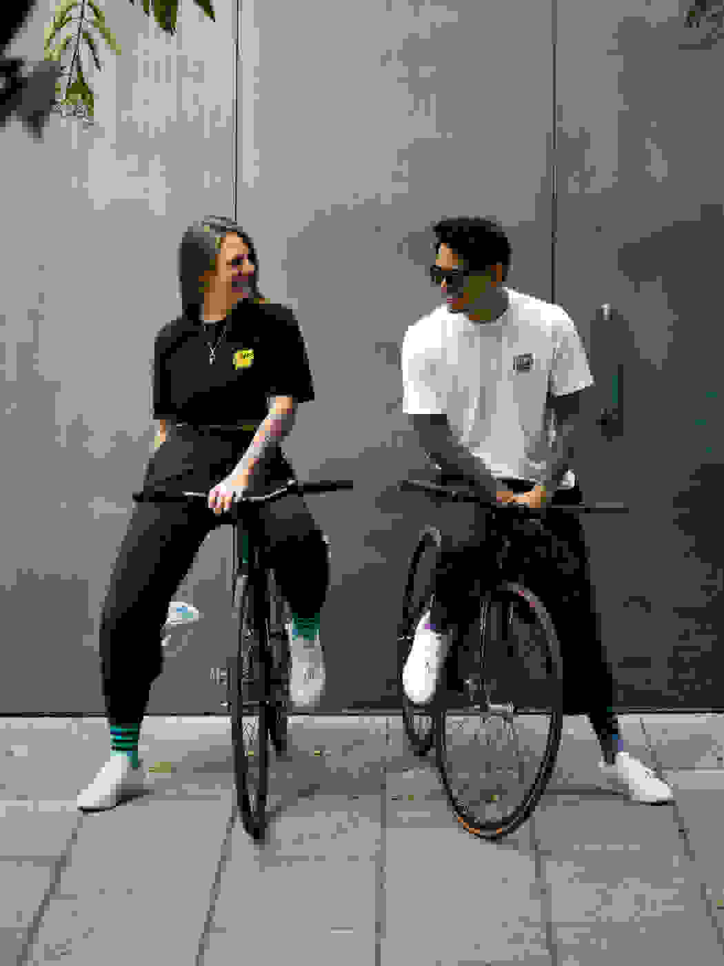 Two people sat on bicycles in front of a green door