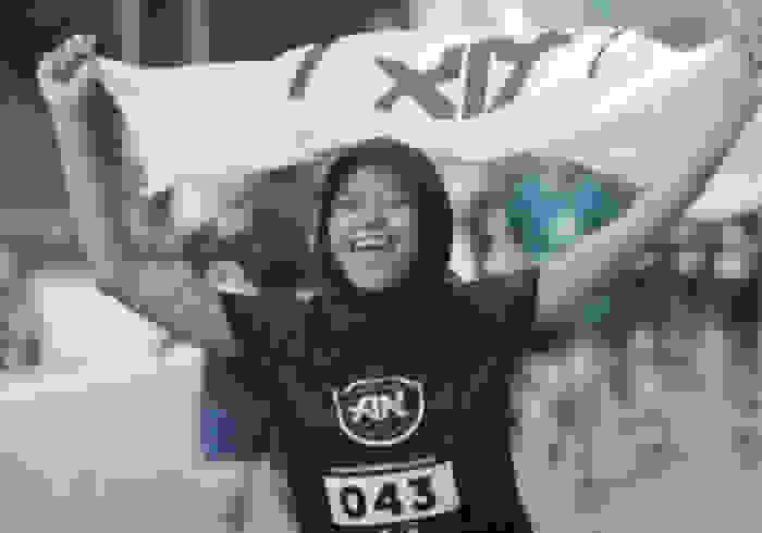 Kuala Lumpur captain Nabila Sam smiles, holding an adidas Runner flag.