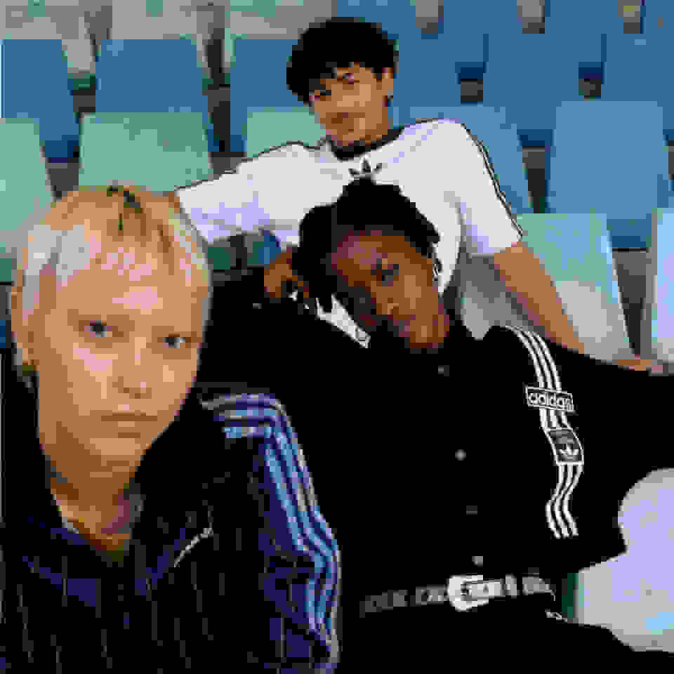 Three people relaxing on the bleachers of a sports facility giving attitude to the camera. 