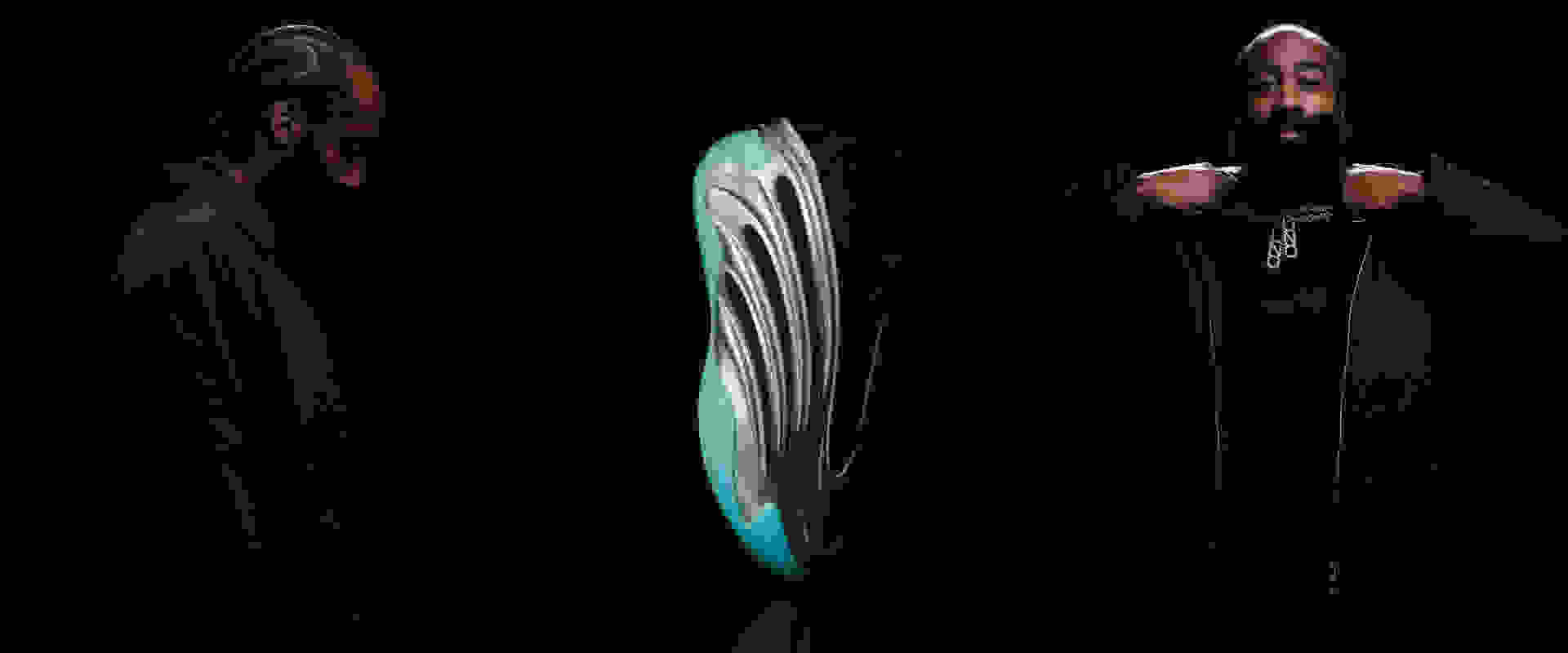 Two individuals wearing dark robes stand on either side of a large, glowing, circular object against a dark background.