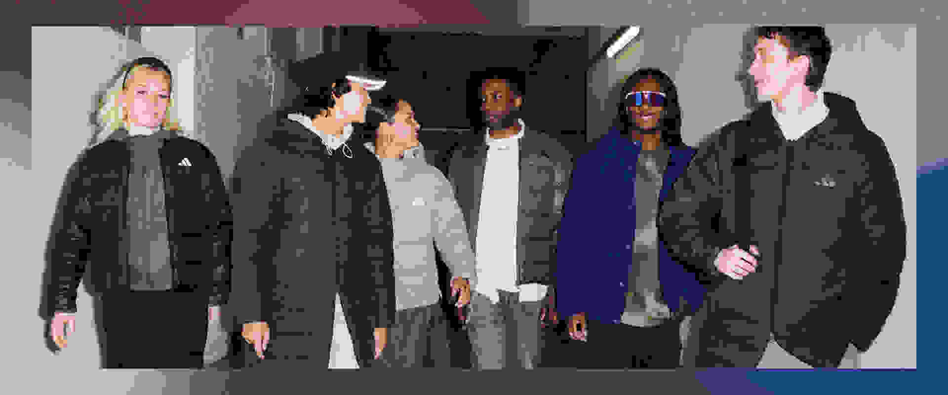 A group of people wearing winter coats and jackets, standing in what appears to be a hallway or indoor setting.