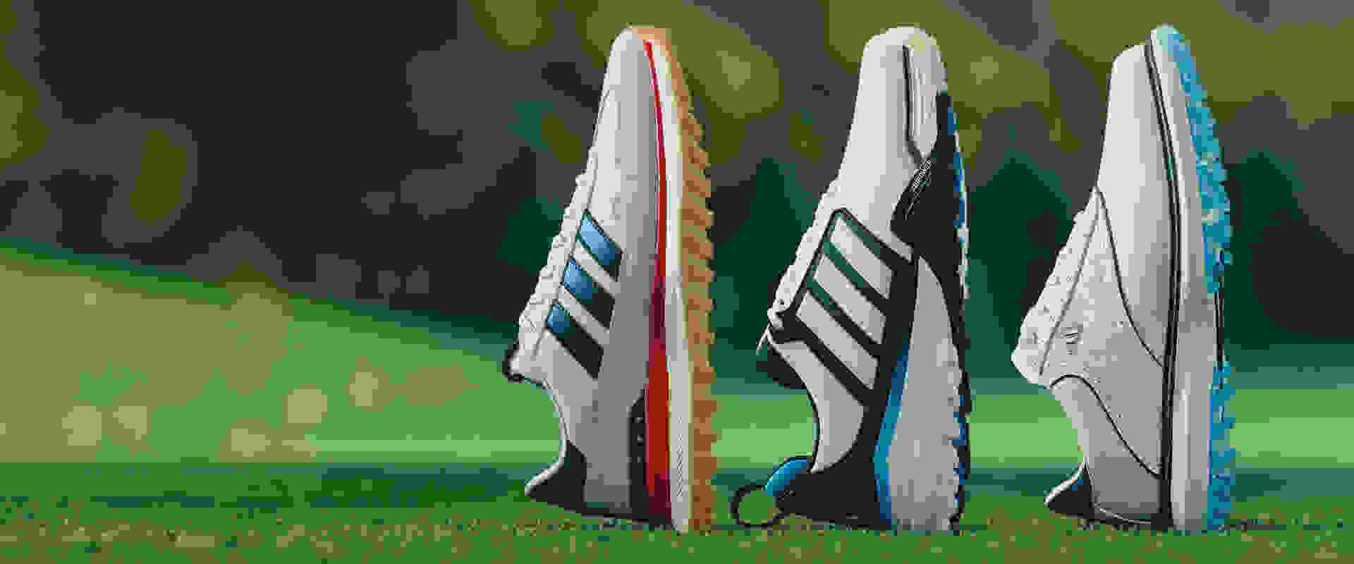Drie paar sportschoenen met opvallende patronen en kleuren schitteren op een weelderig groen grasveld.