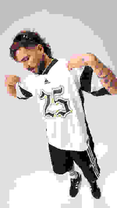 A man wearing a white sports jersey with the number 25 printed on it, standing against a plain background.