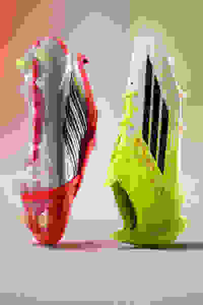 Two colorful and stylized soccer cleats are prominently displayed against a soft, gradient background.