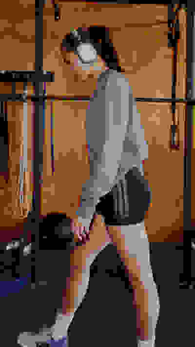 Image of model wearing the Optimé Collection in a gym environment. Hover over of another image with the same model doing a strength exercise.
