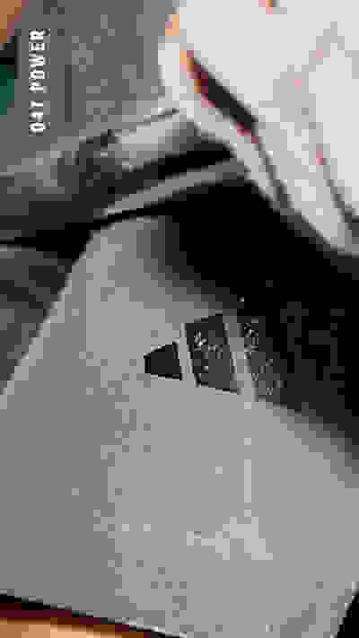 Das Bild zeigt eine Nahaufnahme einer grauen, strukturierten Oberfläche mit einem kleinen, dreieckigen Symbol oder Logo in der Mitte.