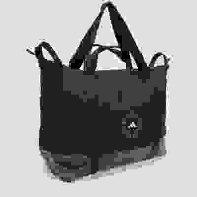 A black, rectangular tote bag with the Adidas Stella McCartney logo prominently displayed on the front.