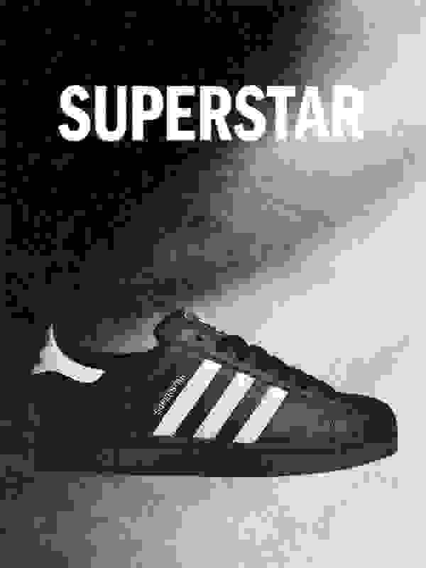 Bildet viser en svart og hvit adidas Superstar-sko mot en mørk bakgrunn, med ordet "SUPERSTAR" tydelig vist over.