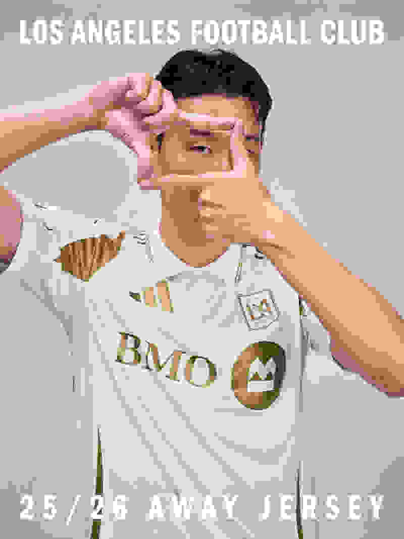 The image shows a person wearing a white soccer jersey with the Los Angeles Football Club logo and the text "BMO" prominently displayed. The person is making a framing gesture with their hands, creating a visual frame around their face.