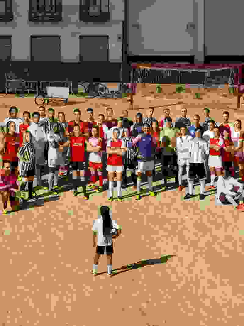 A young girl in front of the professional male and female football players