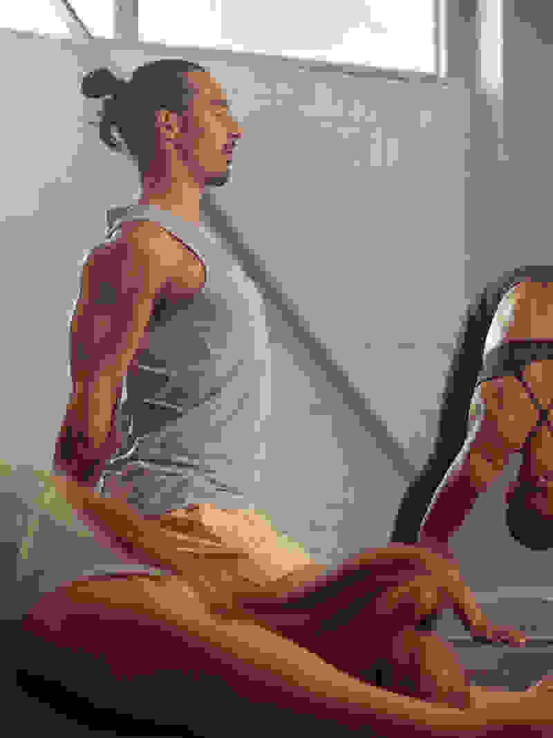 The image depicts two individuals, a man and a woman, engaged in a physical activity or exercise on a mat in what appears to be a fitness or training facility.